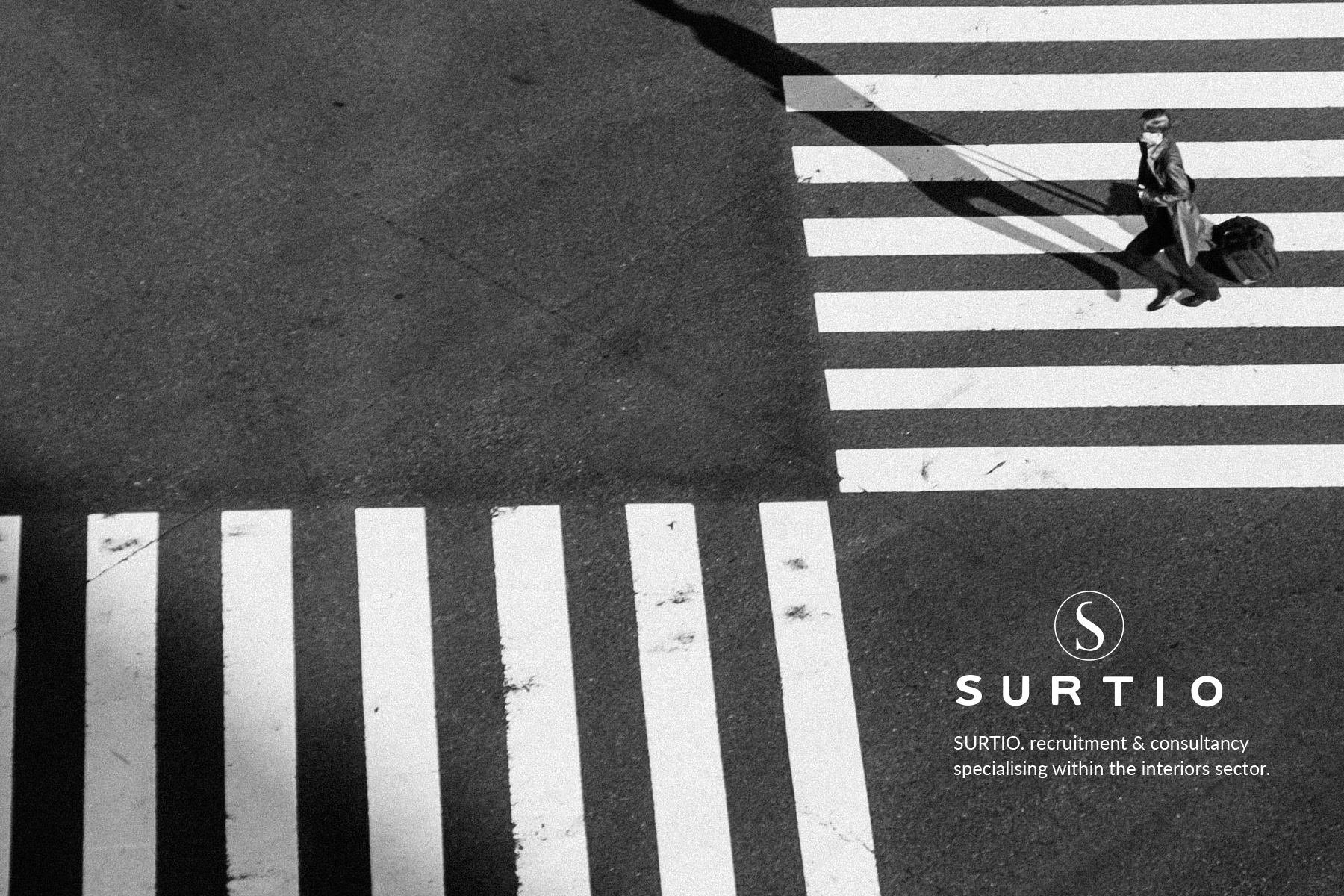 Person crossing at a pedestrian crossing with Surtio branding